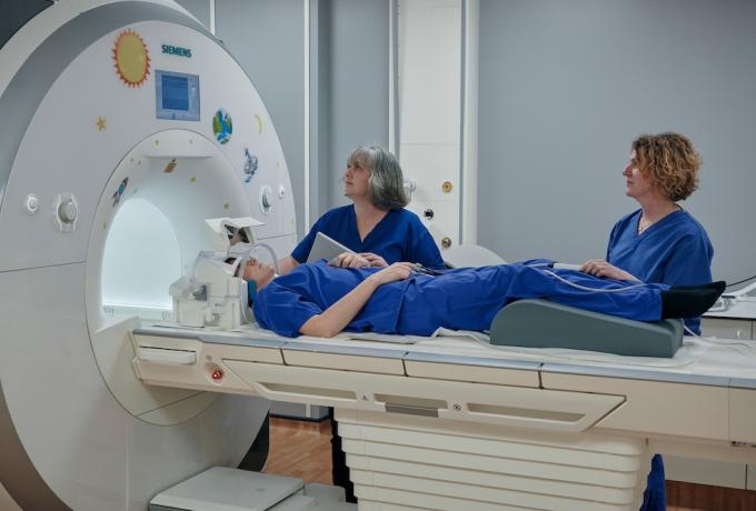 Radiographer Gayle Barclay and colleague examine a patient with an MRI machine