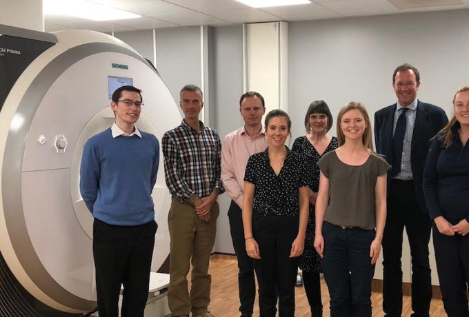Some of the MSS4 study team stands in front of an MRI scanner
