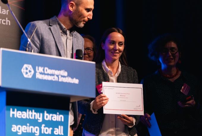 A researcher with her award certificate