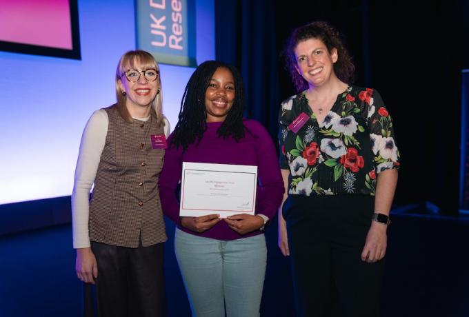 A researcher with her award certificate