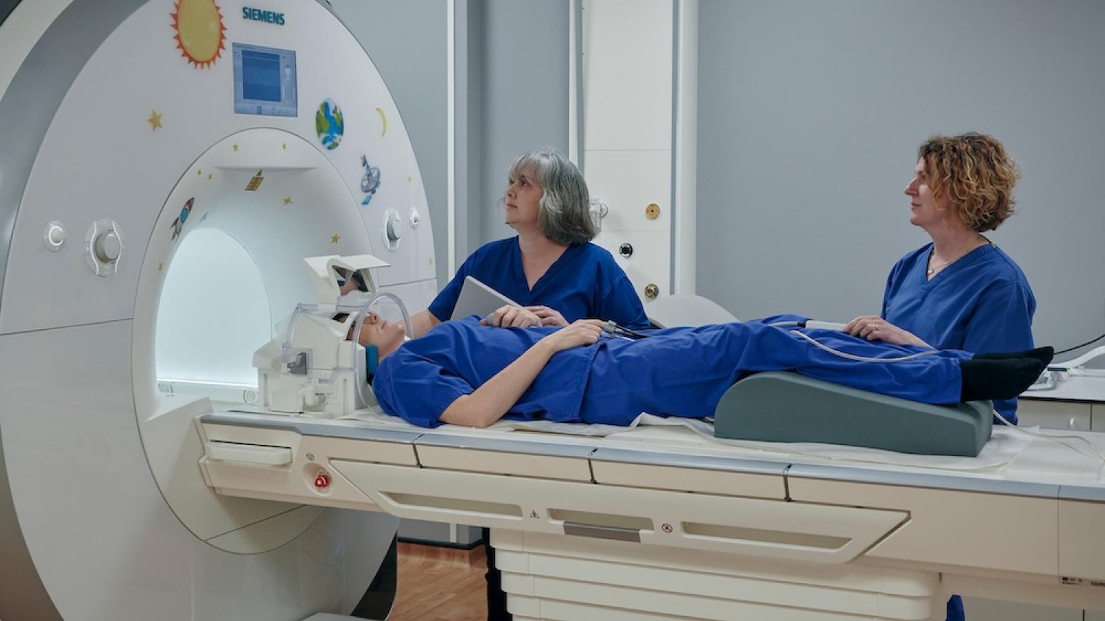 Radiographer Gayle Barclay and colleague examine a patient with an MRI machine
