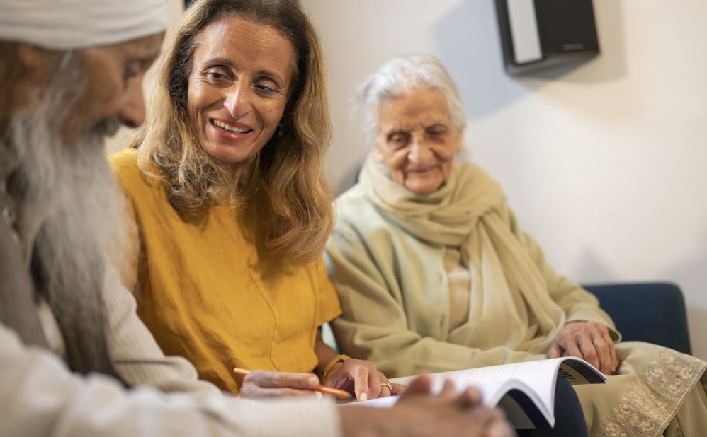 Woman with older parents sitting on sofa