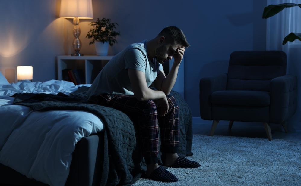 man sitting on bed at night