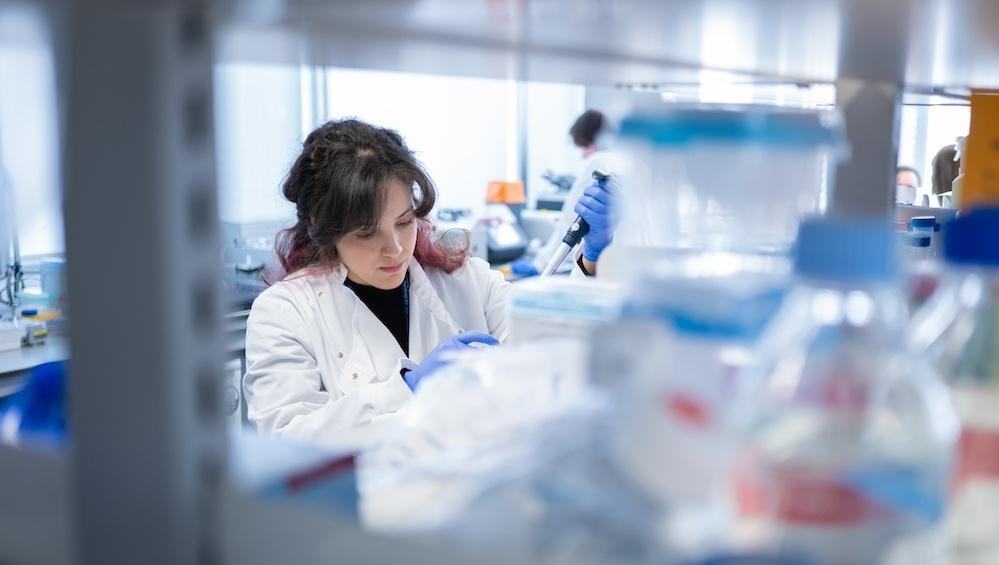 Researcher in a white coat in a lab